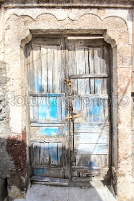 A very worn and battered old blue door