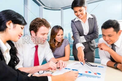 Asian business team discussing report