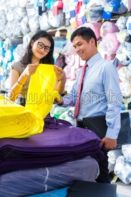 Asian colleagues in a warehouse choosing cloths