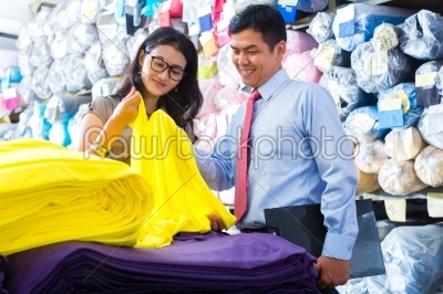 Asian colleagues in a warehouse choosing cloths