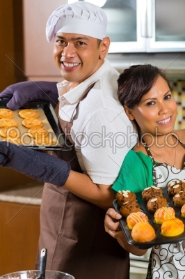 Asian couple baking cake in home kitchen