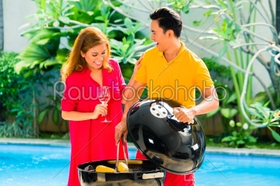 Asian couple having barbecue at the pool