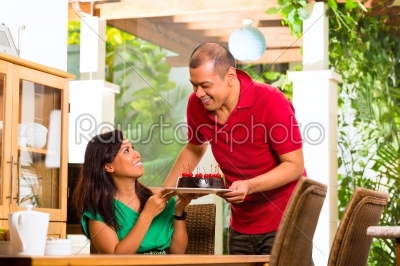 Asian couple having coffee in living room
