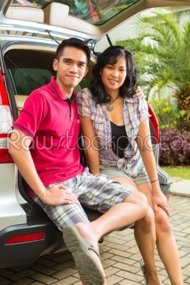 Asian couple is happy in front the car