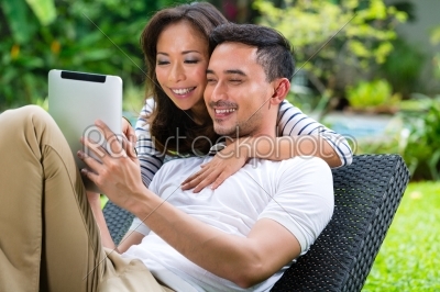 Asian couple outdoor with a tablet pc