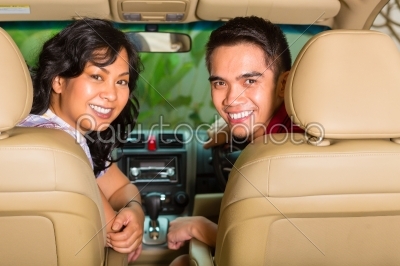 Asian couple sitting in car 