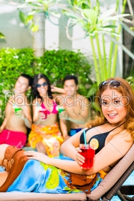Asian friends partying at pool party in hotel