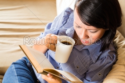 Asian girl with cup reading book