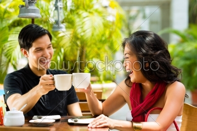 Asian man and woman in restaurant or cafe