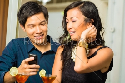Asian man is flirting with woman in bar