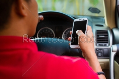 Asian man texting while driving