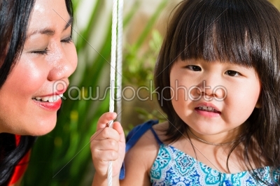 Asian Mother and daughter at home in garden