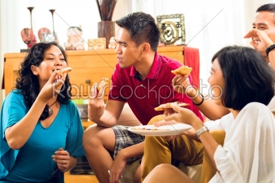 Asian people eating pizza at party