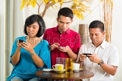 Asian people having fun with mobile phone