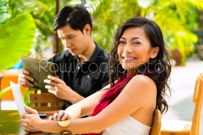 Asian people in cafe with computer