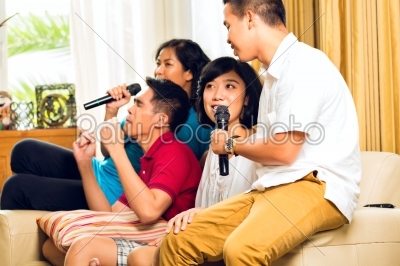 Asian people singing at karaoke party