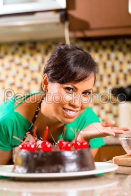 Asian woman baking  chocolate cake in kitchen