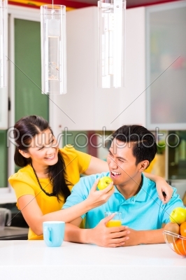 Asian woman feeding boyfriend with apple 