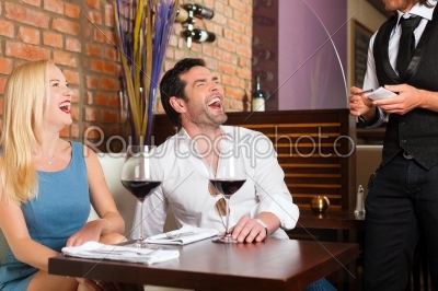 Attractive couple drinking red wine in restaurant or bar