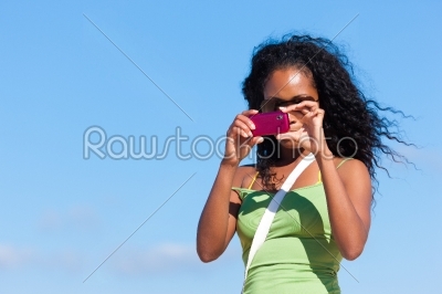 Attractive woman at the beach taking picture