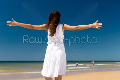 Attractive woman standing in the sun on beach