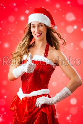 Attractive young woman in Santa Claus costume with thumbs up
