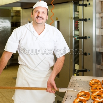 Baker in his bakery baking bread