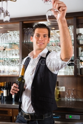 Barman standing behind bar with wine