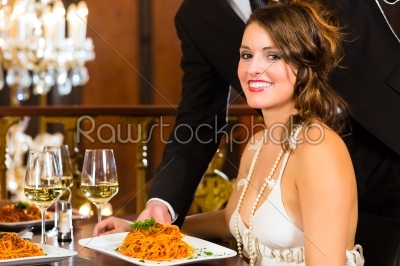 Beautiful woman and waiter in fine dining restaurant