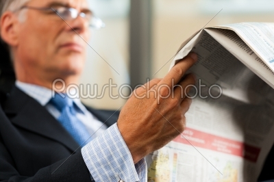 Boss in his office reading newspaper