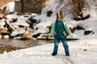 Boy with snow on river in Winter