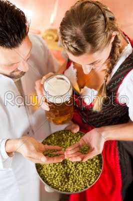 brewer and woman with beer glass in brewery