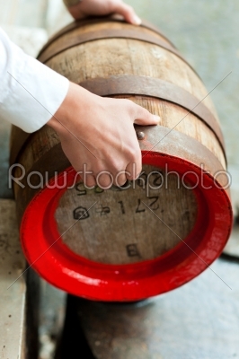 Brewer with beer barrel in brewery 