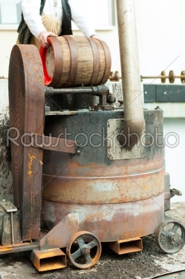 Brewer with beer barrel in brewery 