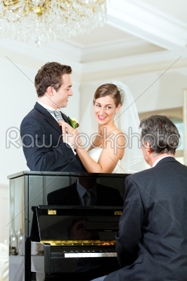 Bridal couple in front of a piano