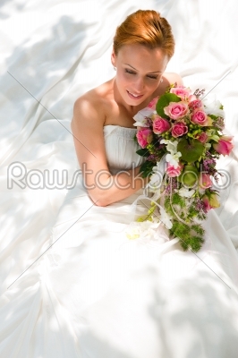 Bride sitting holding a bouquet of flowers in her hand