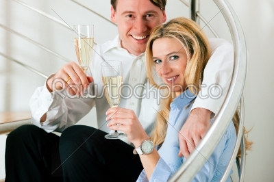 Business Couple at home with champagne