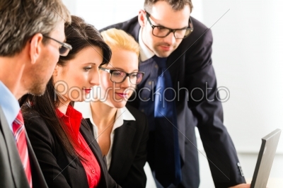 Businesspeople looking at laptop screen