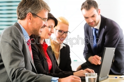 Businesspeople looking at laptop screen