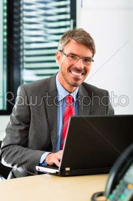 businessperson with laptop in his business office