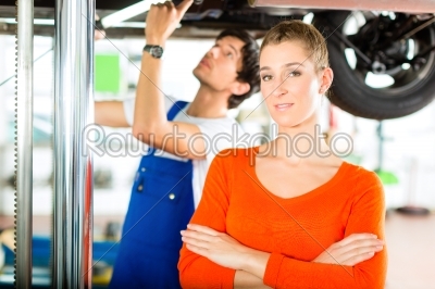 Car Mechanic repairing auto of woman customer