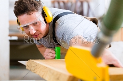 Carpenter using electric saw in carpentry