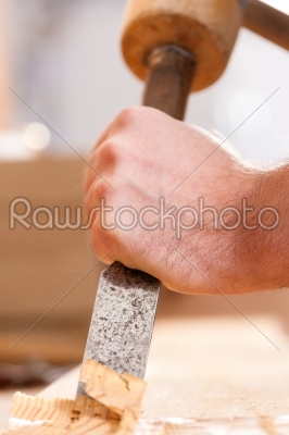 Carpenter with chisel and hammer
