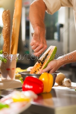 Chef preparing fruits in restaurant or hotel kitchen
