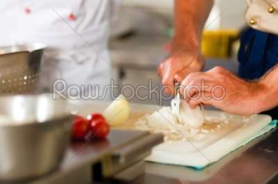 Chef preparing onion in restaurant or hotel kitchen