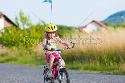 Child cycling outdoors in summer