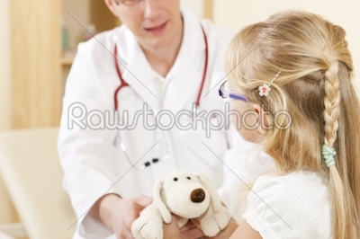 Child giving a soft toy to doctor