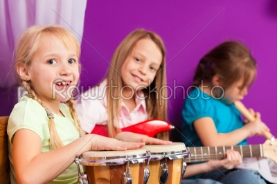 Children making music with instruments at home