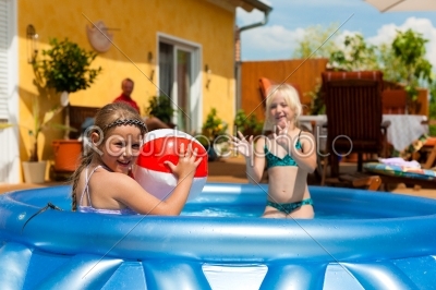 Children playing with ball in water pool