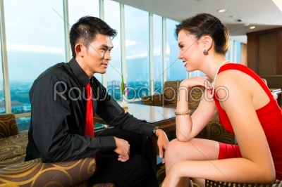 Chinese couple flirting in a luxury sky hotel bar